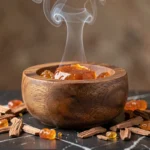 Brûleur d'encens arabe en bois avec résine oud fumante sur marbre sombre, encens traditionnel envoûtant