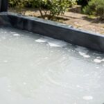 Eau trouble et laiteuse dans un spa extérieur avec particules en suspension visibles à la surface