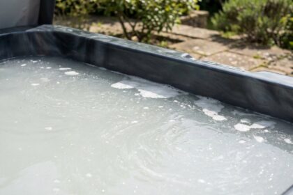 Eau trouble et laiteuse dans un spa extérieur avec particules en suspension visibles à la surface