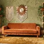 Salon décoré dans un style années 70 bohème avec canapé en velours orange, tapis shag moutarde et suspensions en macramé